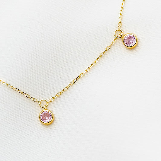 Minimalist 14k gold plated sterling silver station necklace featuring five light pink cubic zirconia bezel drops.