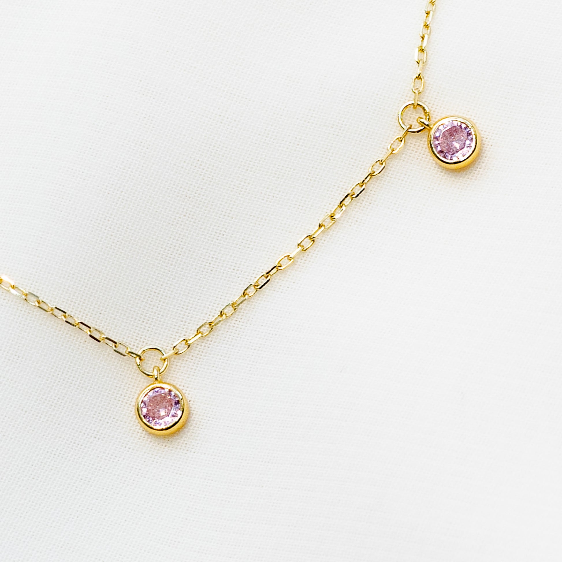 Minimalist 14k gold plated sterling silver station necklace featuring five light pink cubic zirconia bezel drops.