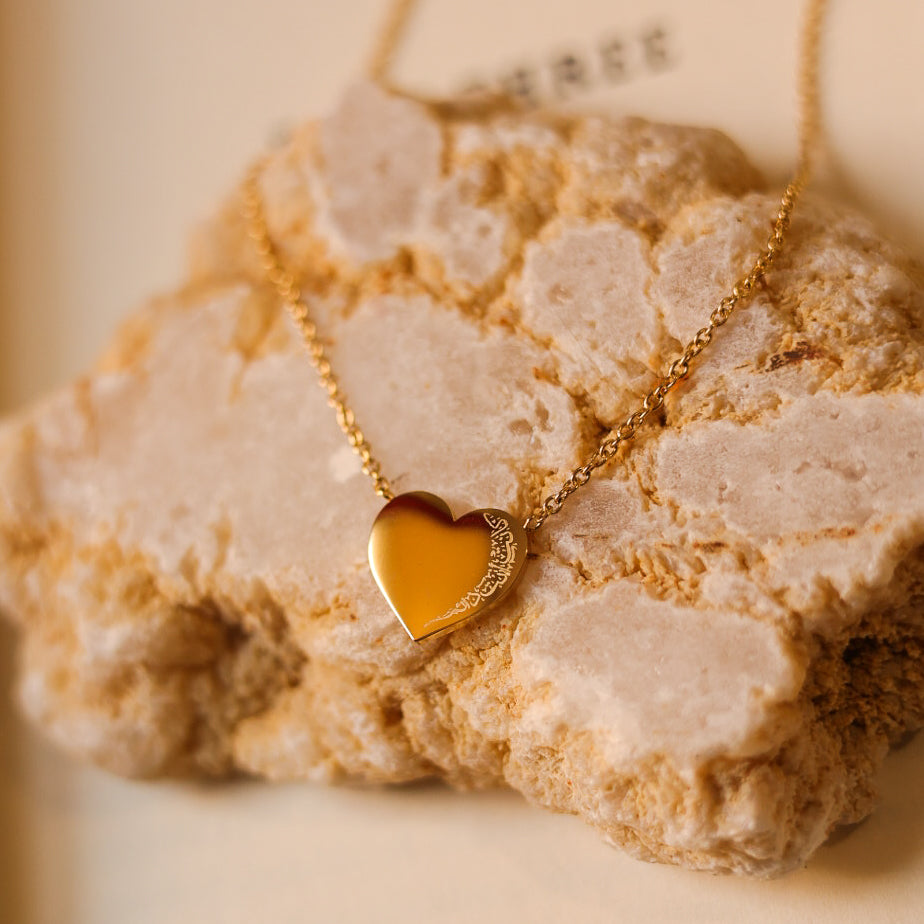 18k gold plated It Was Always You heart necklace with engraved Arabic detail on a natural stone background.