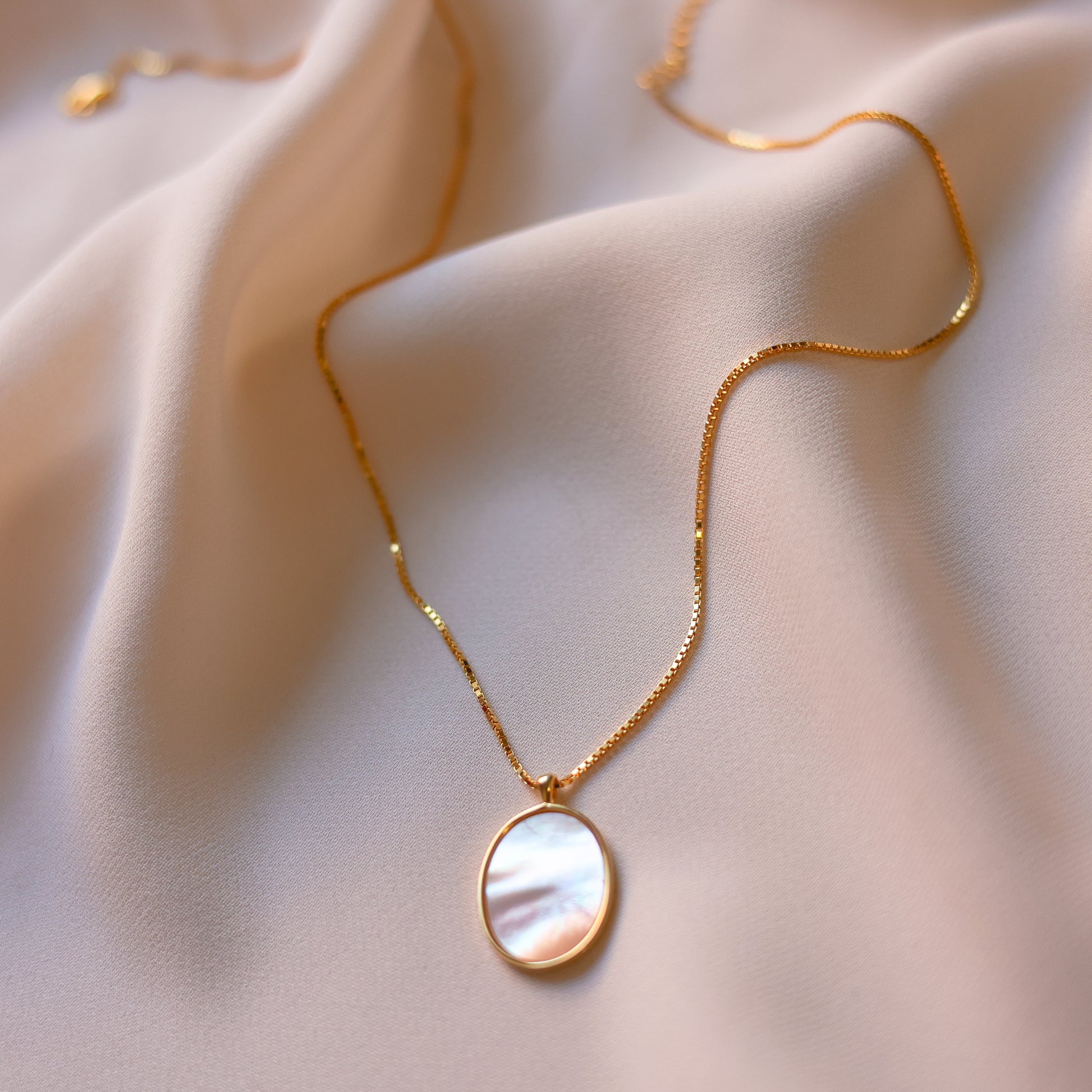 Discover a gold mother of pearl necklace with an oval pendant, soft shimmer, delicate chain, and elegant shine made for everyday wear, layering, or gifting.